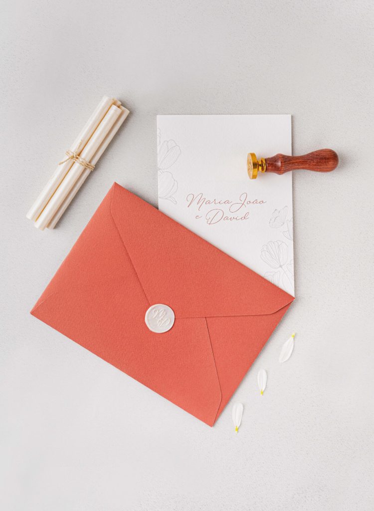 Convite de casamento branco com detalhes tipográficos de cor salmão de estilo floral com um envelope de cor salmão