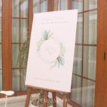 Placa de PVC com detalhes em dourado e detalhes em florais e cavalete em madeira