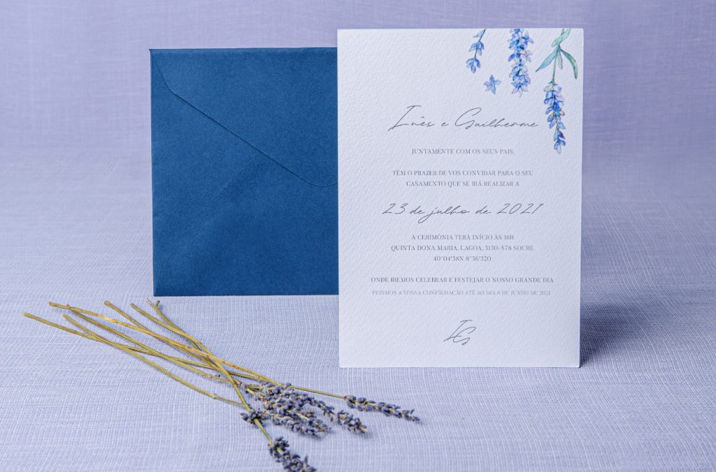 Convite de casamento com detalhes florais azul e envelope azul escuro