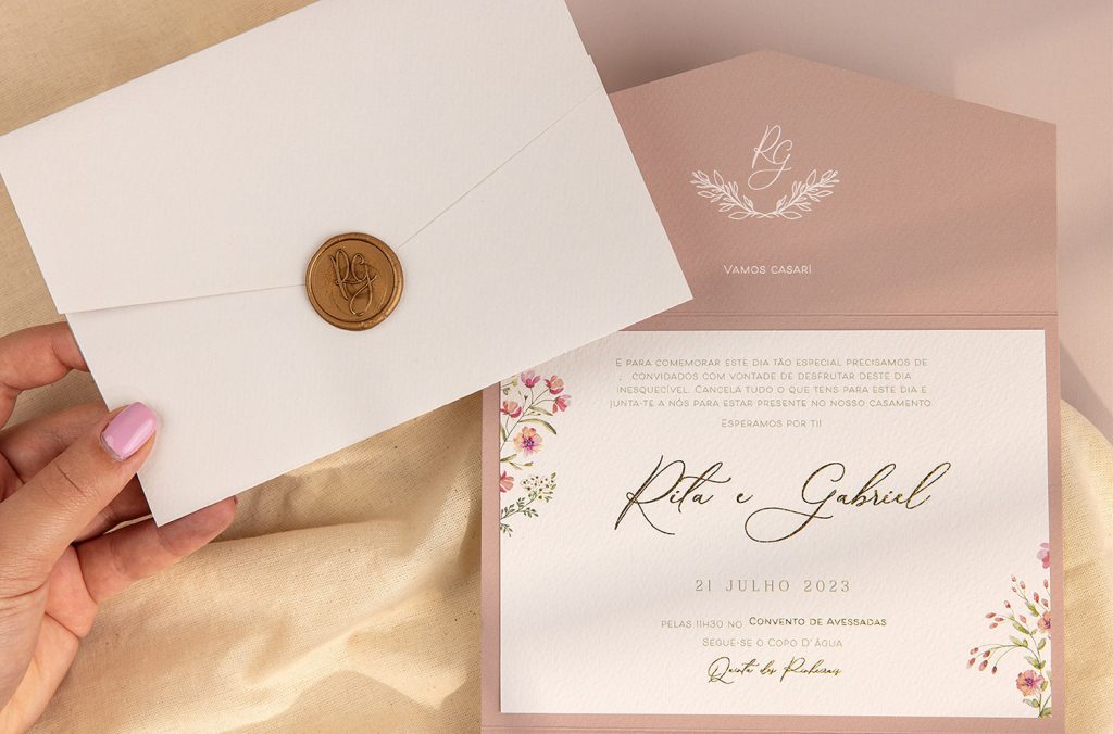 Convite de casamento com detalhes florais e envelope branco com lacre