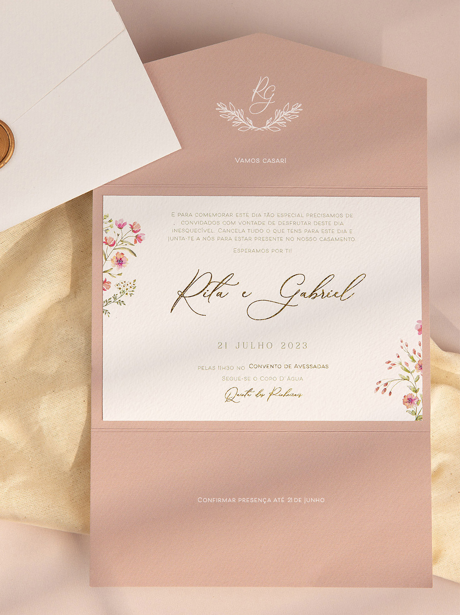 Convite de casamento com detalhes florais e detalhes dourado e envelope branco com lacre dourado fundo rosa