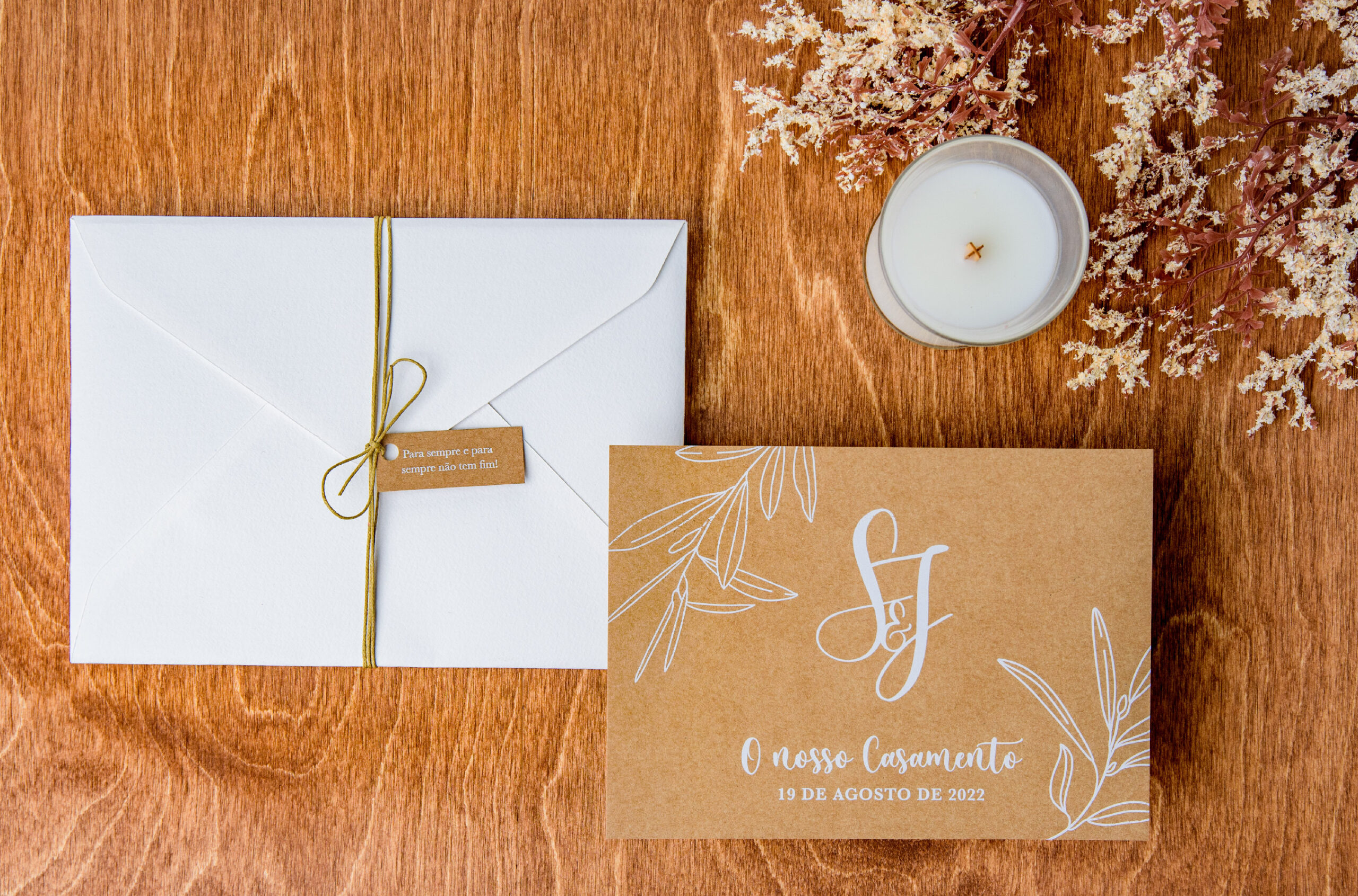 Convite de casamento em Kraft com detalhes florais e envelope branco com fio natural e uma etiqueta