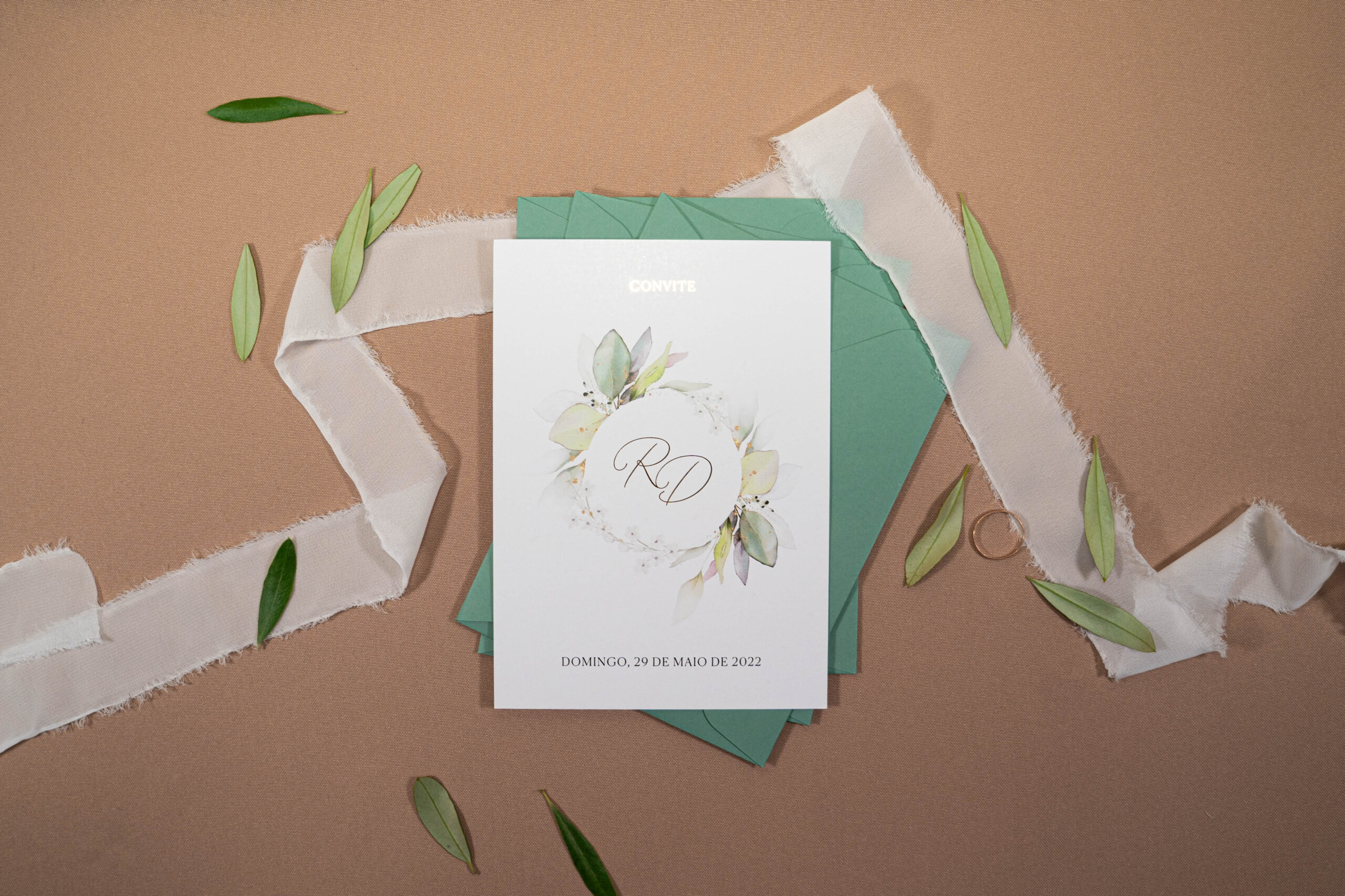 Convite de casamento com detalhes florais e detalhes em dourado com envelope