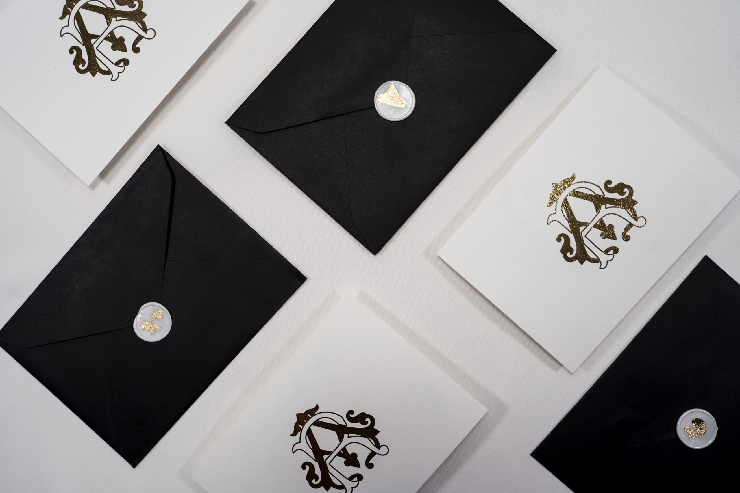 Convite de Casamento com detalhes em dourado e envelope preto com lacre branco e detalhes em dourado