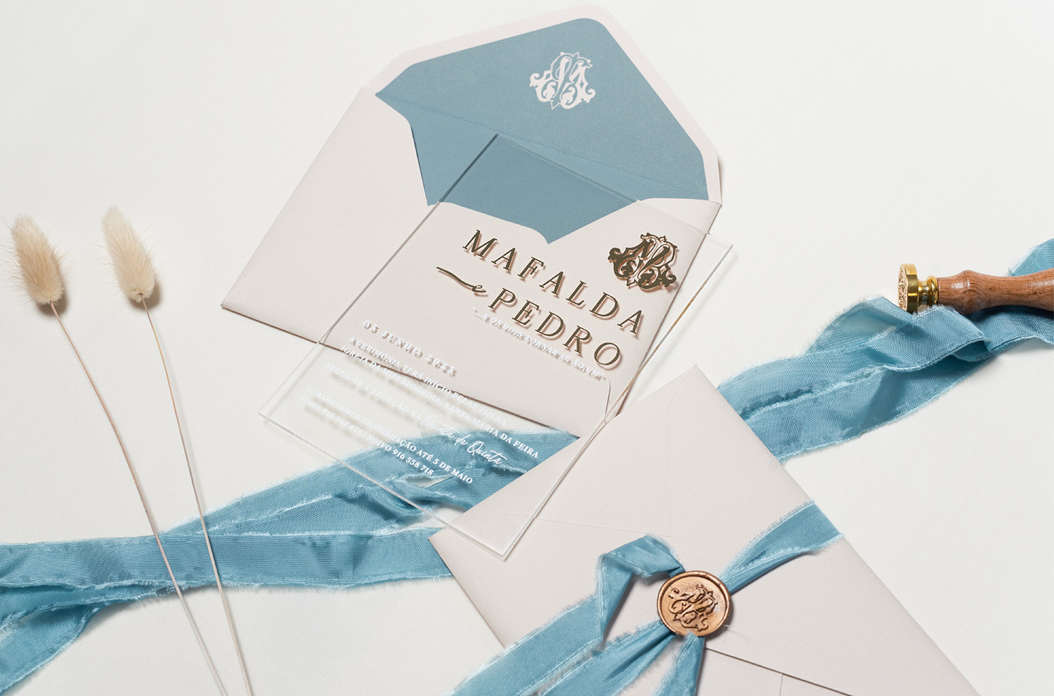 Convite de Casamento acrílico com detalhes em dourado e uma envelope azul com lacre dourado e fio azul