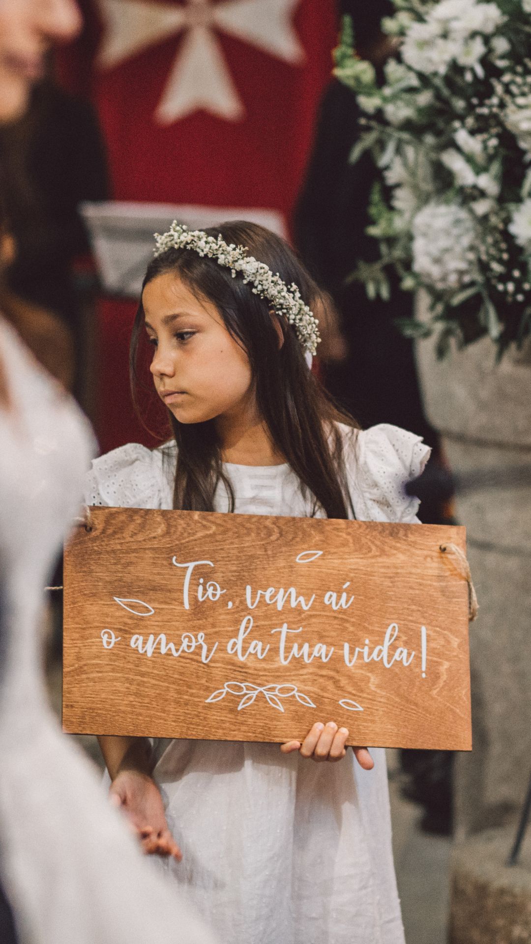 Menina com placa de menino das alianças em madeira com fio natural