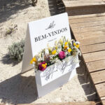 Placa de boas vindas com detalhes florais e um cesto com flores