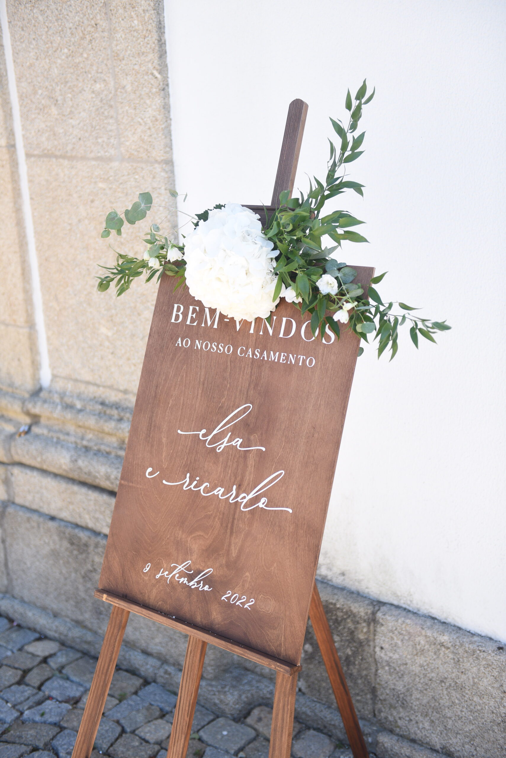 Placa de boas vindas em madeira e um cavalete em madeira com detalhes florais