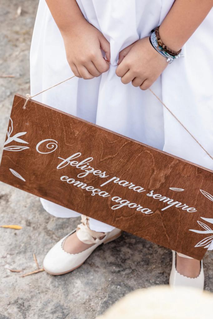 Menina com placa de menino das alianças em madeira com fio natural