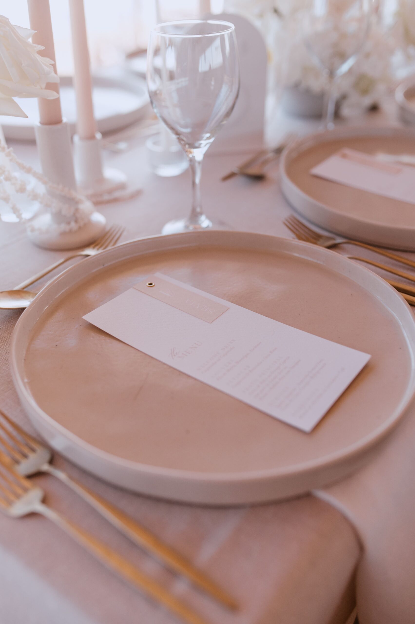 Ementa em papel algodão com marcador de lugar unidos por ilhó como elemento de decoração para mesa de casamento