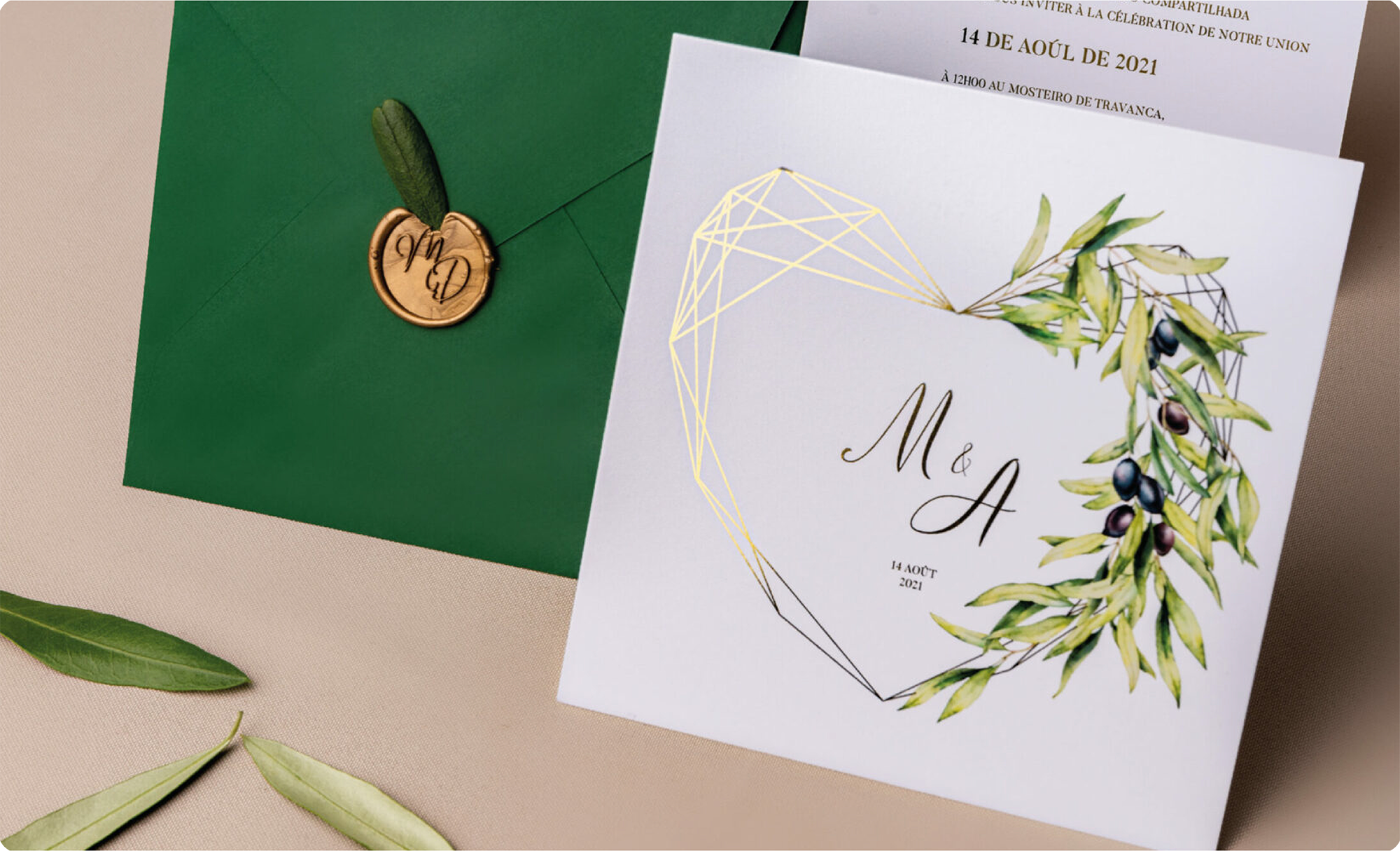 Convite de casamento com detalhes dourados e florais e envelope verde com lacre dourado e folha de oliveira